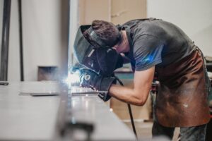 man in grey shirt welding